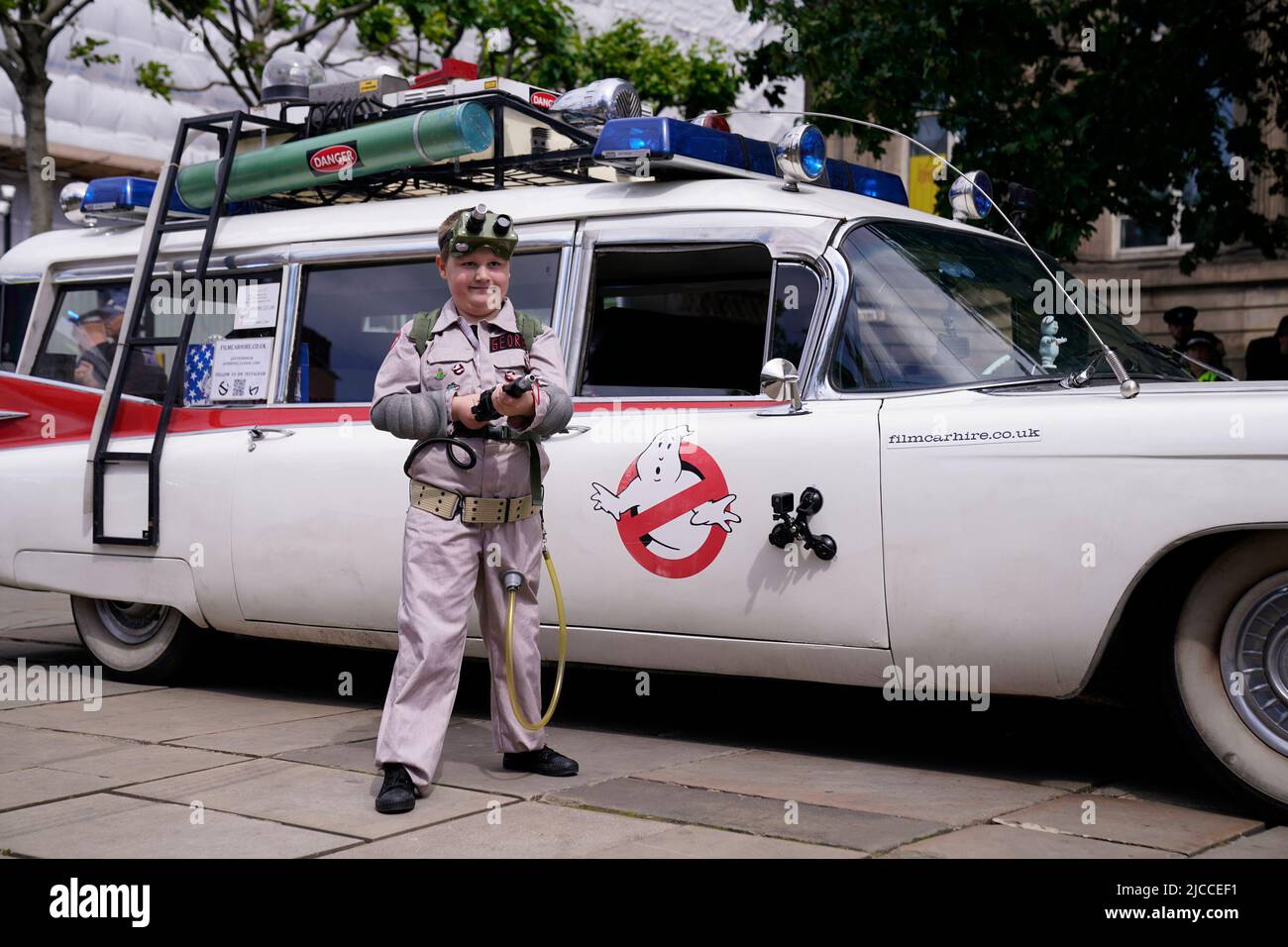Ghostbusters superfan George Hinkins, eight, from Harrogate, who has a serious heart condition, stands by 'ECTO-1' as he makes his way to search Leeds Central Library for 'ghosts', during a Ghostbusters day in Leeds put on by Make a Wish. Picture date: Sunday June 12, 2022. Stock Photo