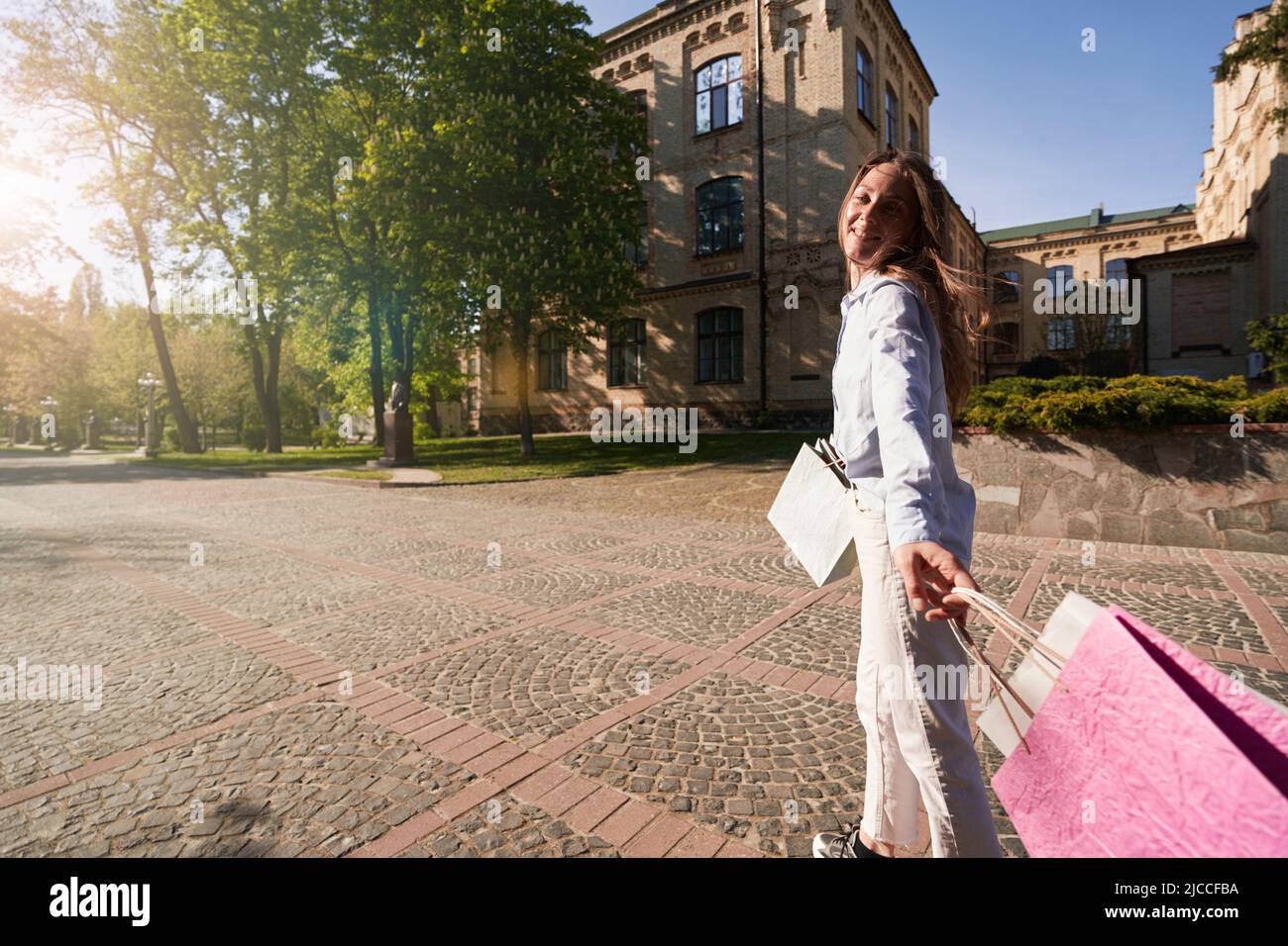 carefree-female-relaxing-after-going-shopping-in-old-city-stock-photo