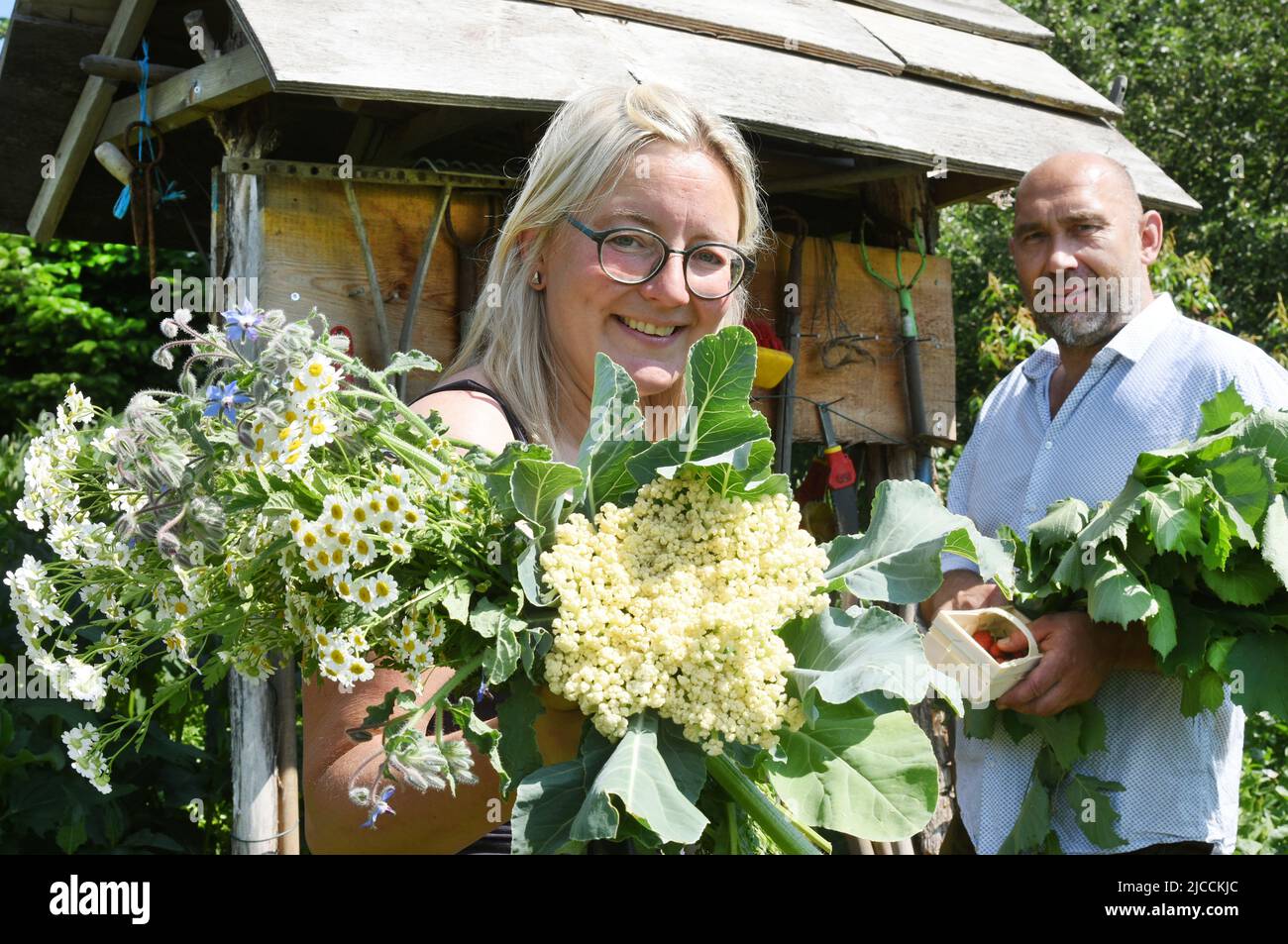 12 June 2022, Saxony, Taucha Bei Leipzig: For the Open Garden Day,  sociologist and herb educator Antje Thiel and her life partner, landscape  architect and gardener Axel Thiel, stand with herbs and