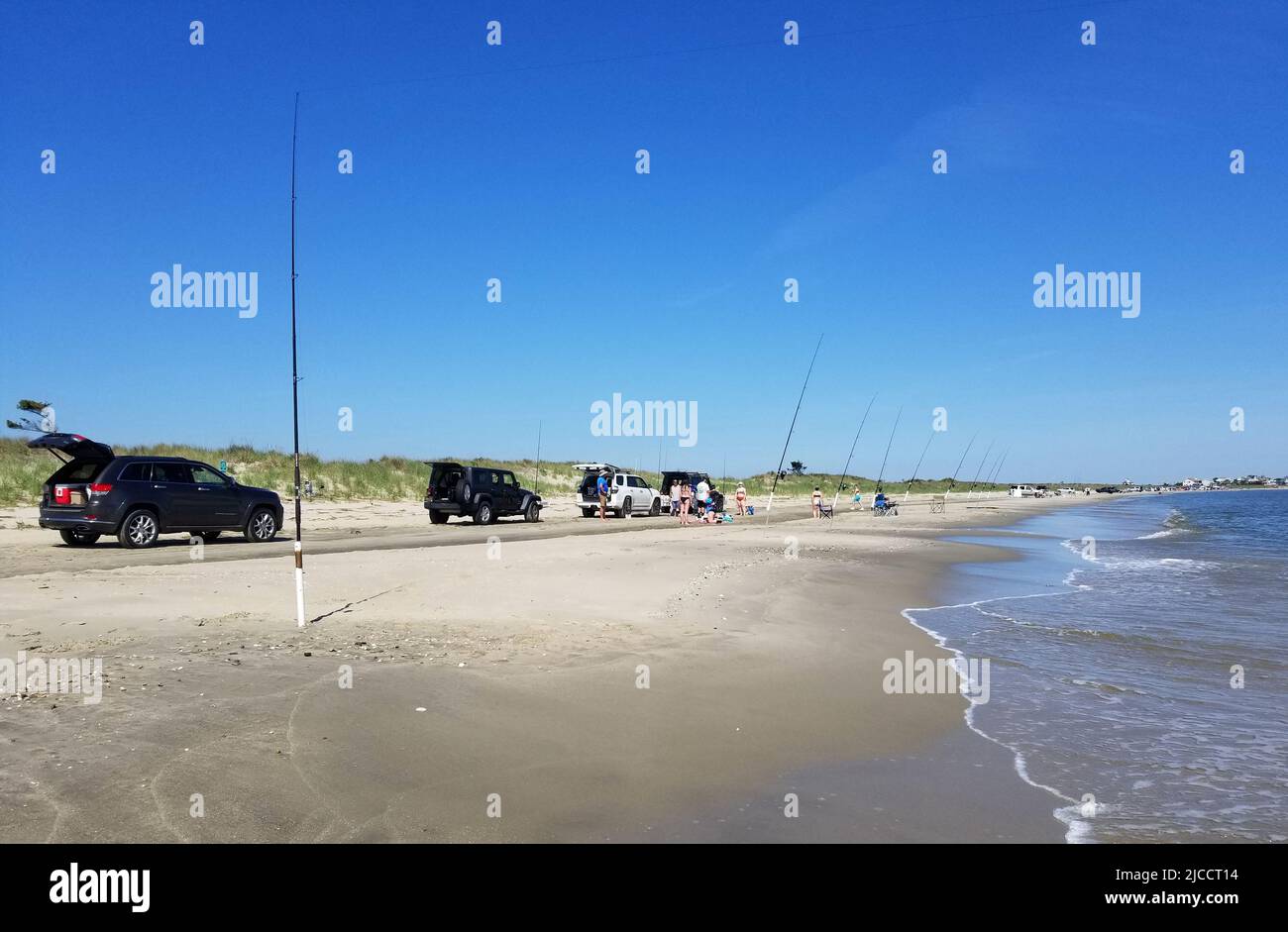 Broadkill Beach, Delaware, U.S.A - May 16, 2022 - Trucks and cars parked on the beach overlooking the surfishing rods Stock Photo