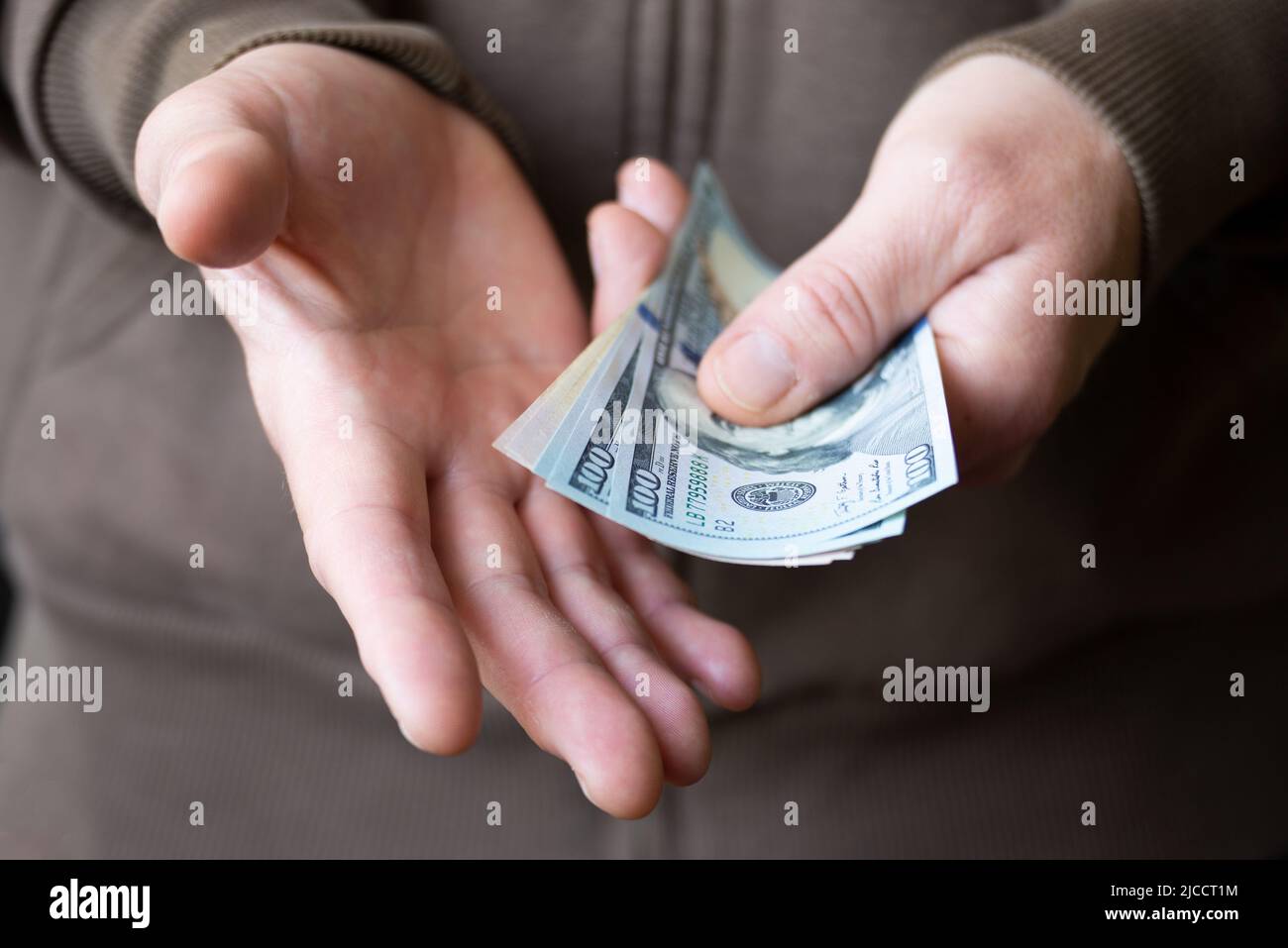 White male shows dollar bills in his hand closeup front view Stock Photo