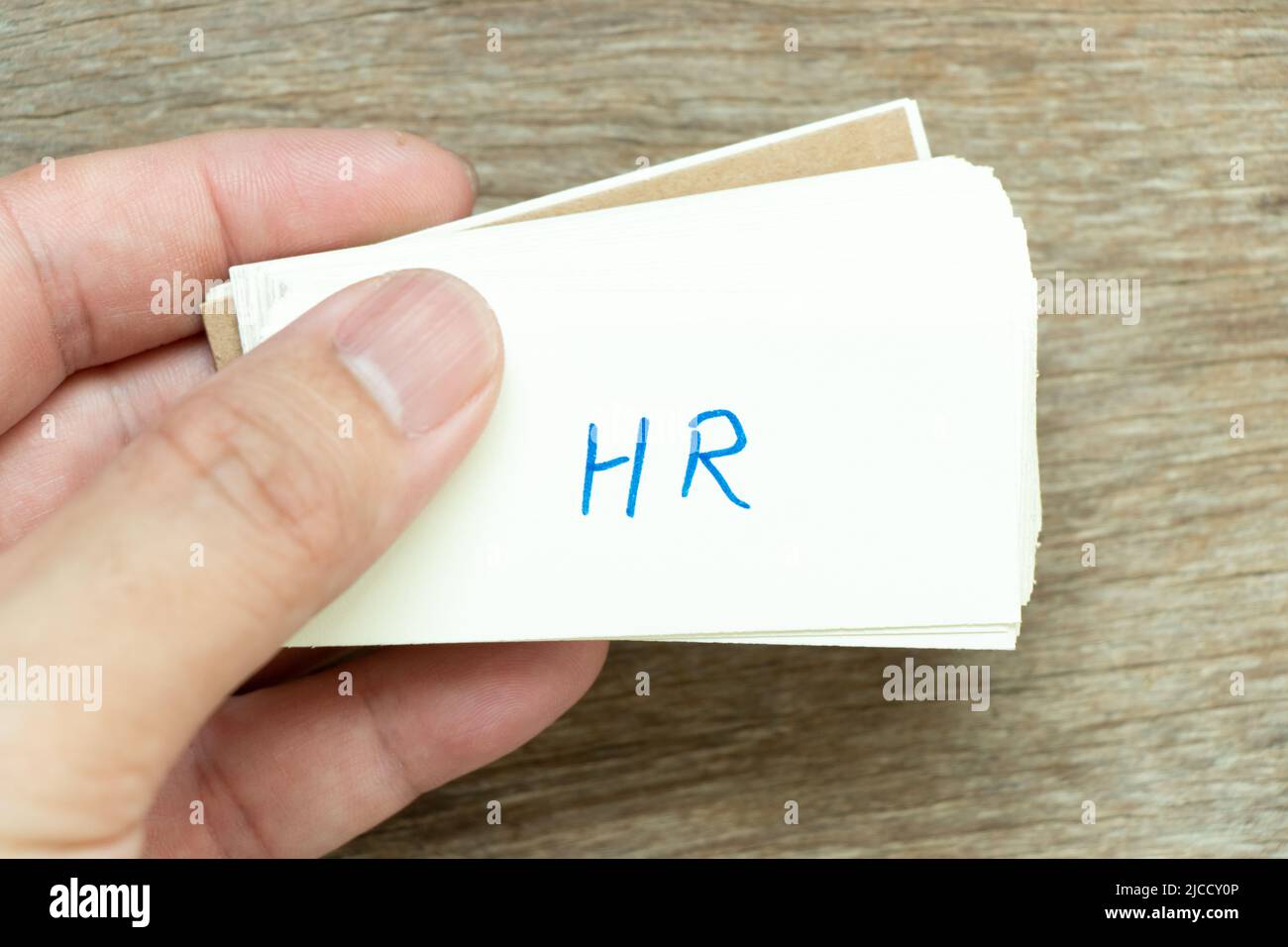 Man hold the flash card with handwriting word HR (Abbreviation of human
