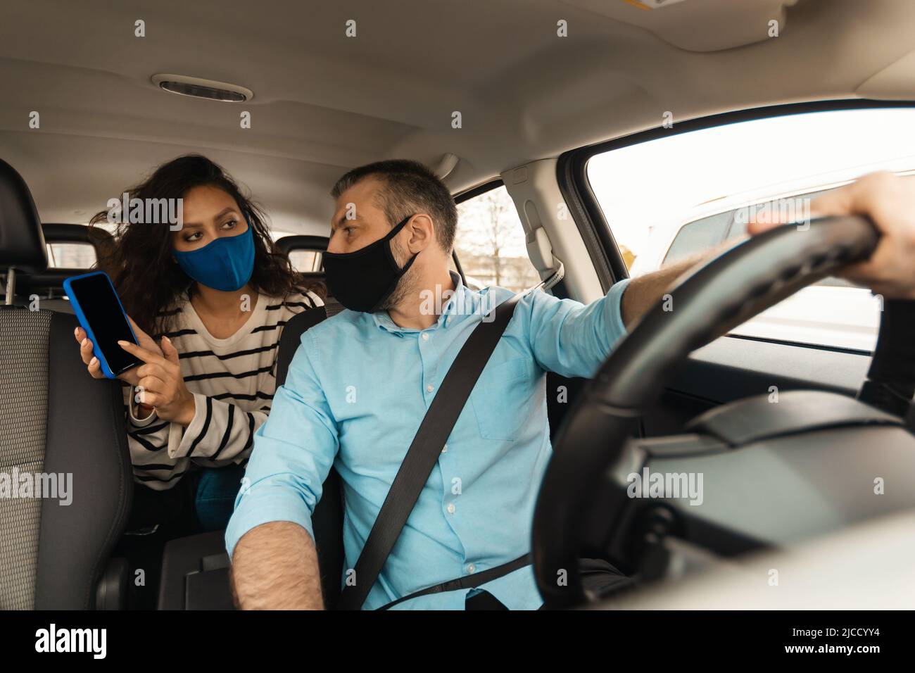 Couple Driving Automobile And Using Mobile Phone Traveling By Auto Stock Photo