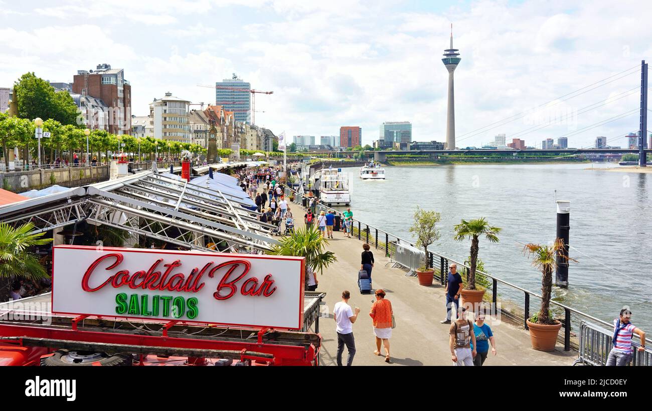 The Rhine River promenade in Düsseldorf/Germany on a summer day. The landmark Rhine Tower is visible in the background. Stock Photo