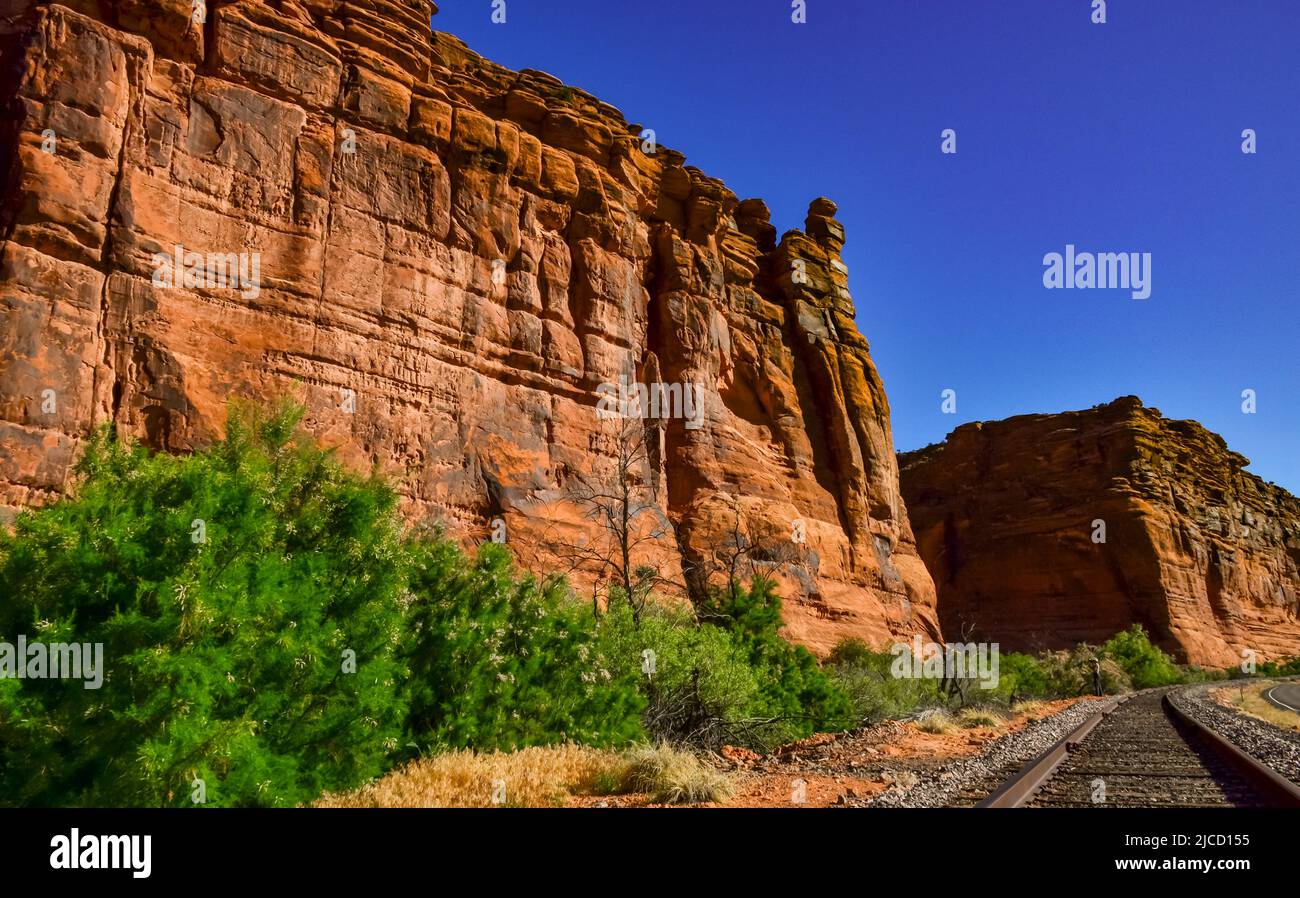 Railroad at the bottom of a canyon next to Layered Geological ...