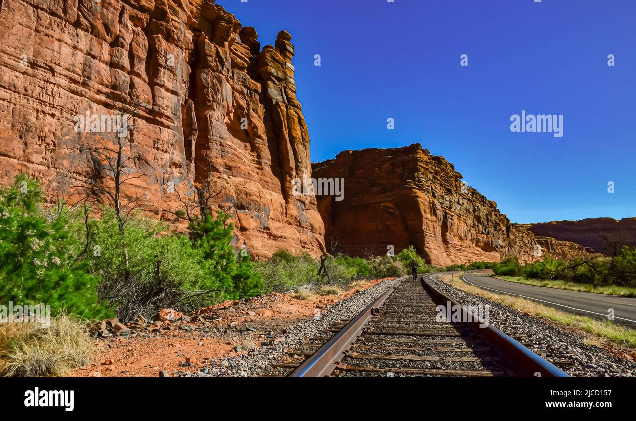 Railroad at the bottom of a canyon next to Layered Geological ...