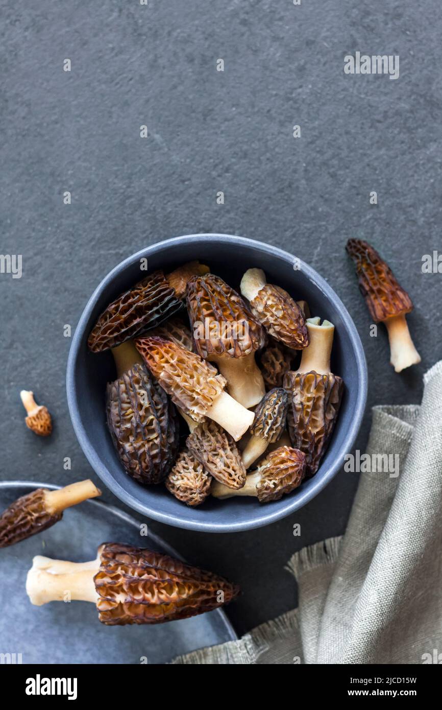 Morel mushrooms in a blue bowl  Flat lay, copy space Stock Photo
