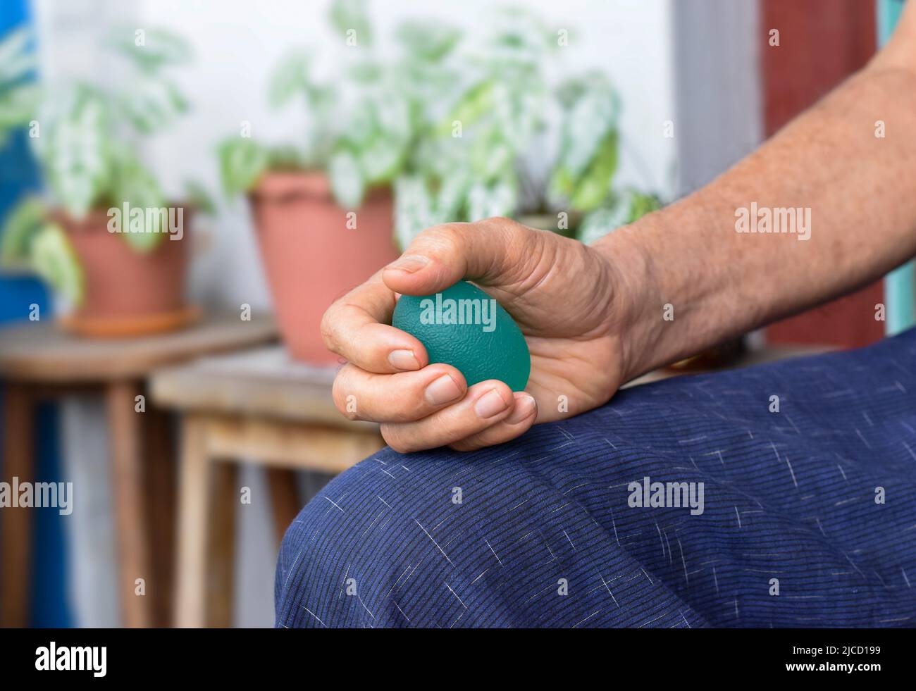 Southeast asian, Chinese old man gripping hand exercise elastic ball. Stock Photo