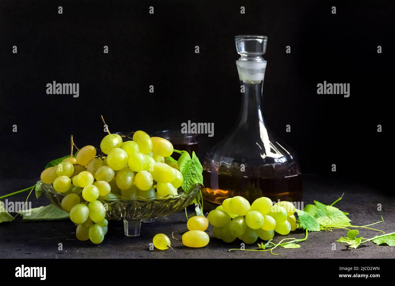 Fresh ripe grapes in a fruit bowl and decanter with grape juice on