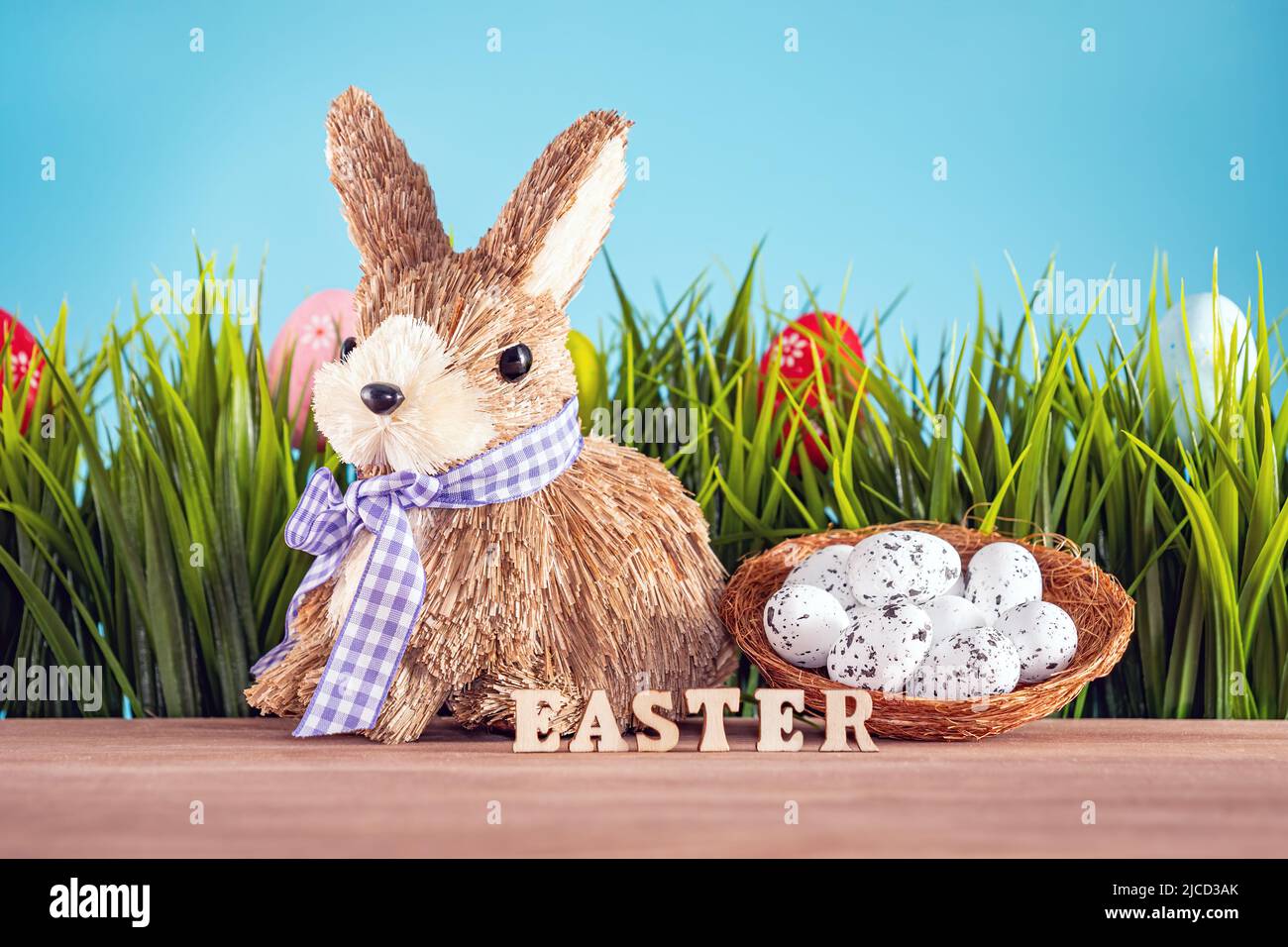 Easter eggs and cute bunny on wood table with green grass. Festive decoration Stock Photo