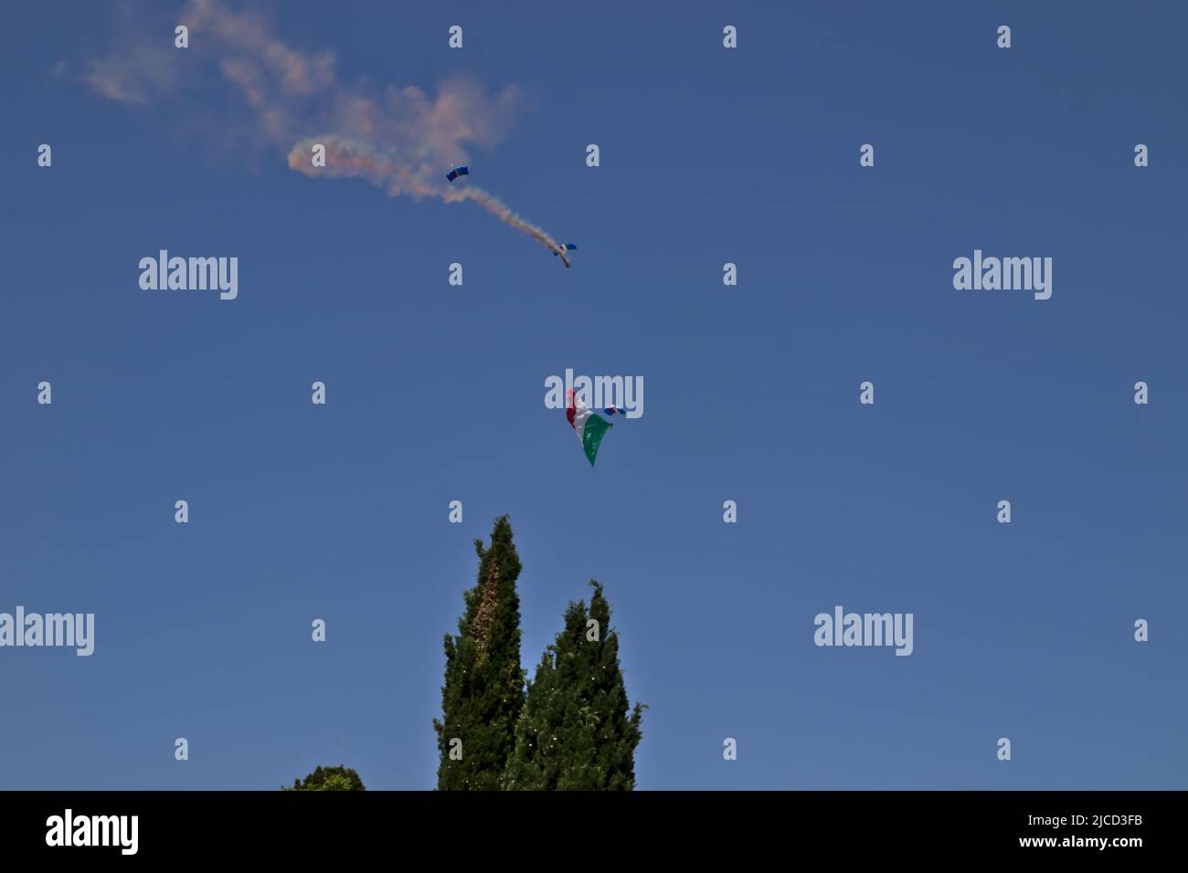 A military paratrooper launched from a helicopter unrolls the Italian flag. Stock Photo