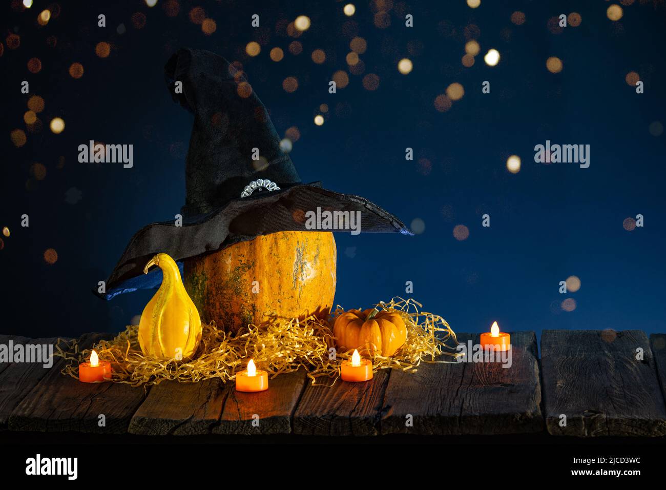 Halloween background with pumpkins, candles on wooden table and bokeh Stock Photo