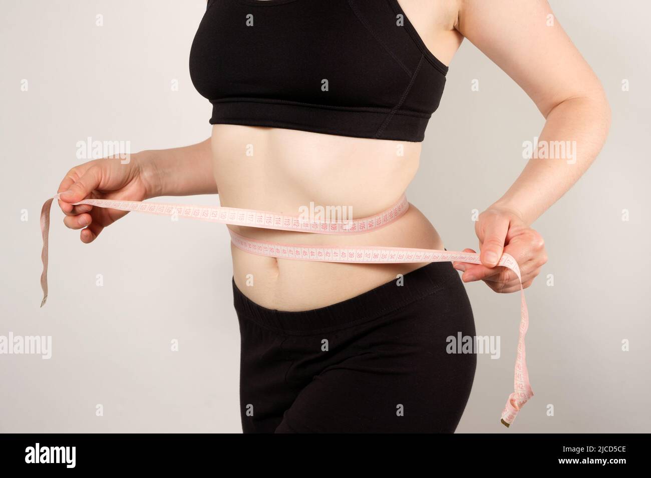 https://c8.alamy.com/comp/2JCD5CE/a-woman-measures-the-circumference-of-the-abdomen-with-a-centimeter-tape-close-up-slimming-concept-2JCD5CE.jpg