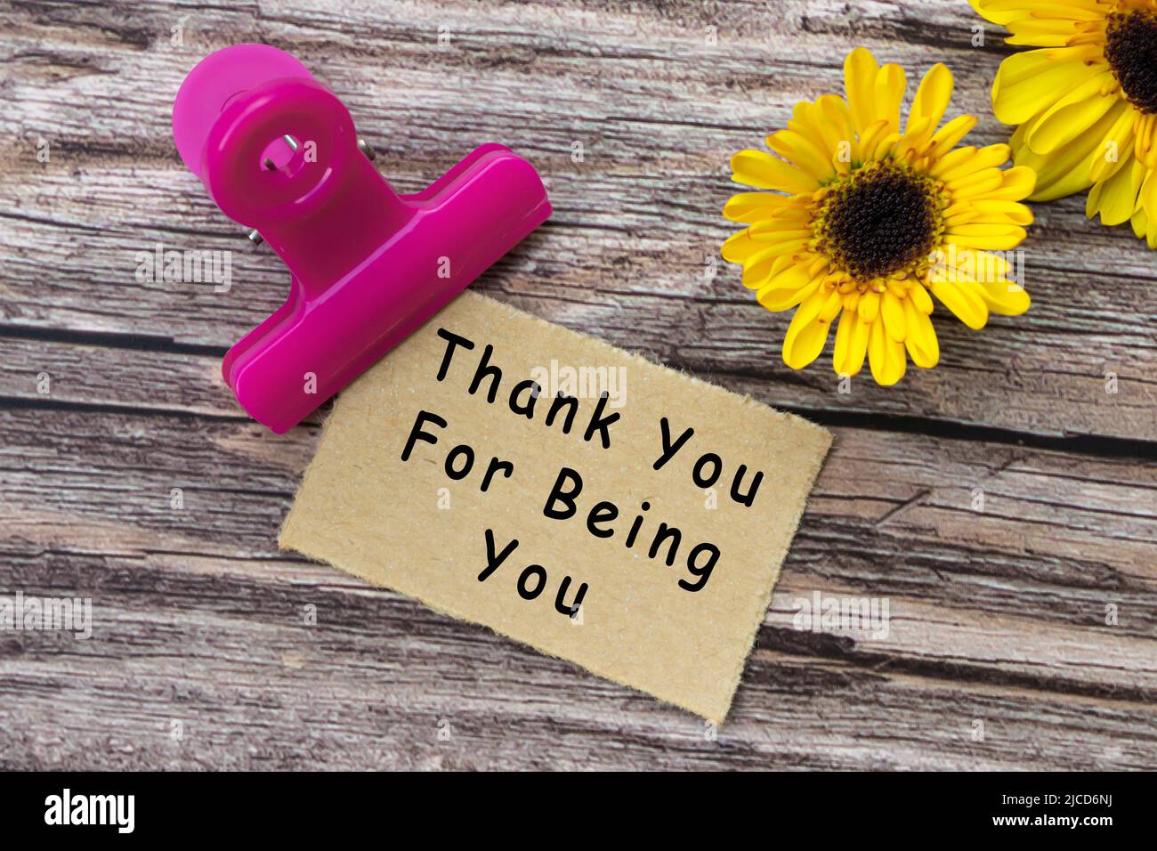 Thank you for being you text on torn brown paper with paper clip holder on  wooden surface. Motivational quote Stock Photo - Alamy