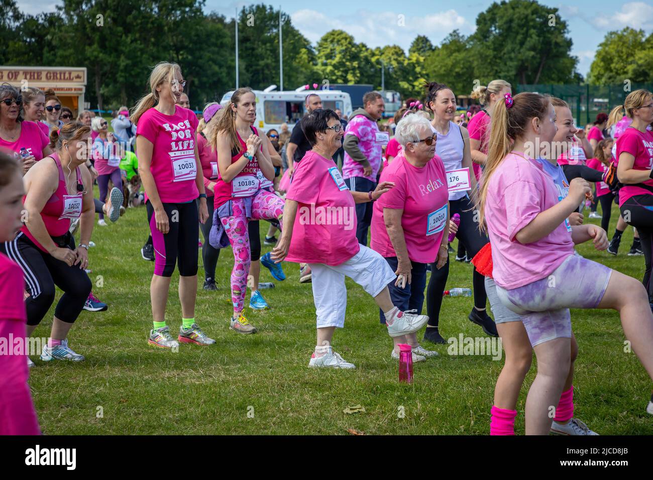 12 June 2022; Warrington Cheshire, UK; Race for Life in Victoria Park in aid of Cancer Research. The runners walm up before the race Credit: John Hopkins/Alamy Live News Stock Photo