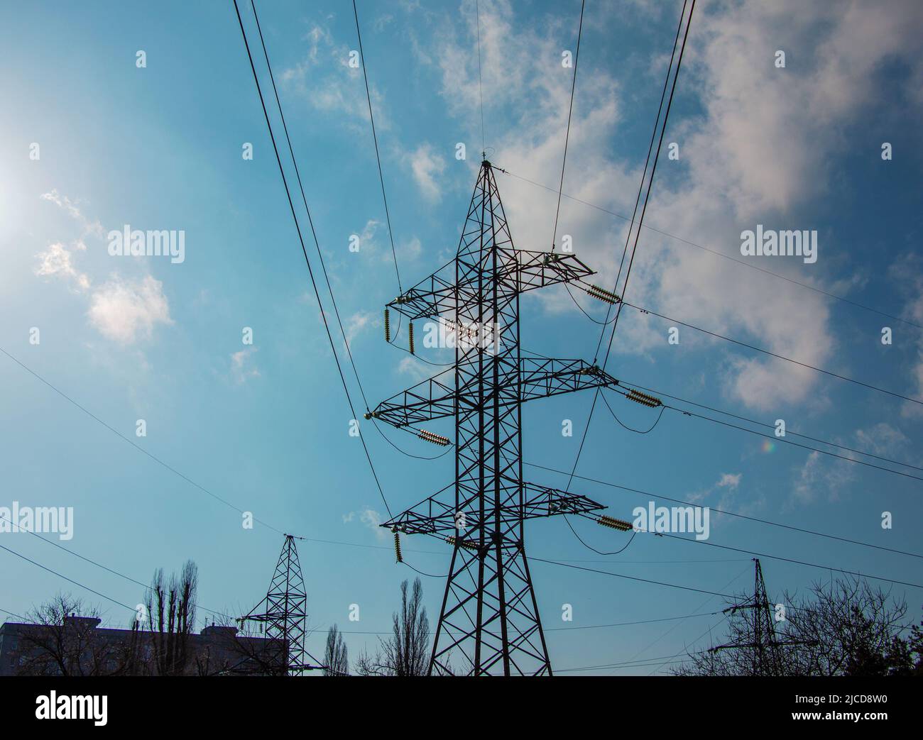 High voltage electric power lines on pylons in blue sky Stock Photo - Alamy
