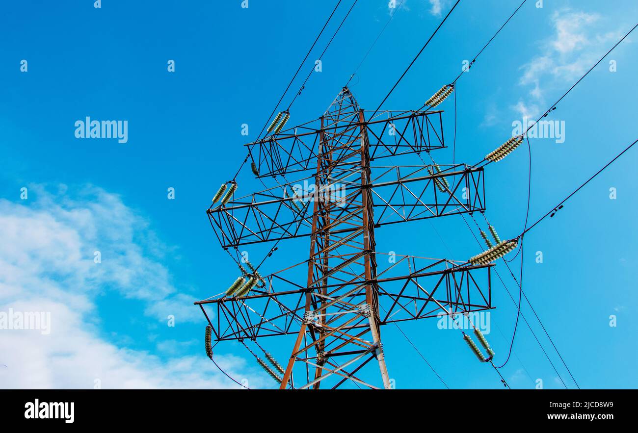 High voltage electric power lines on pylons in blue sky Stock Photo - Alamy
