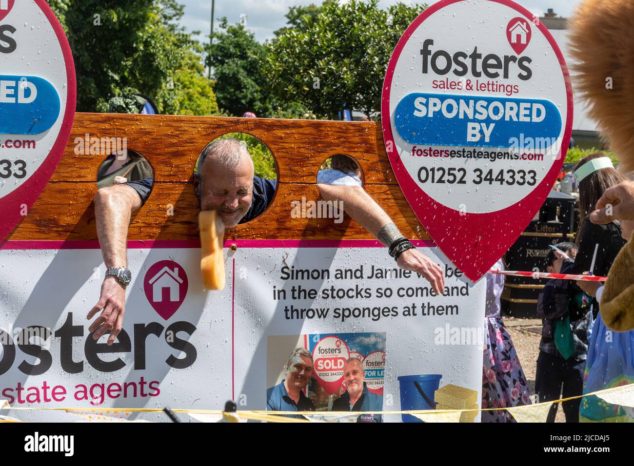 Wet sponge throwing at Victoria Day Event in Aldershot, Hampshire, England, UK, sponsored by Fosters Estate Agents Stock Photo