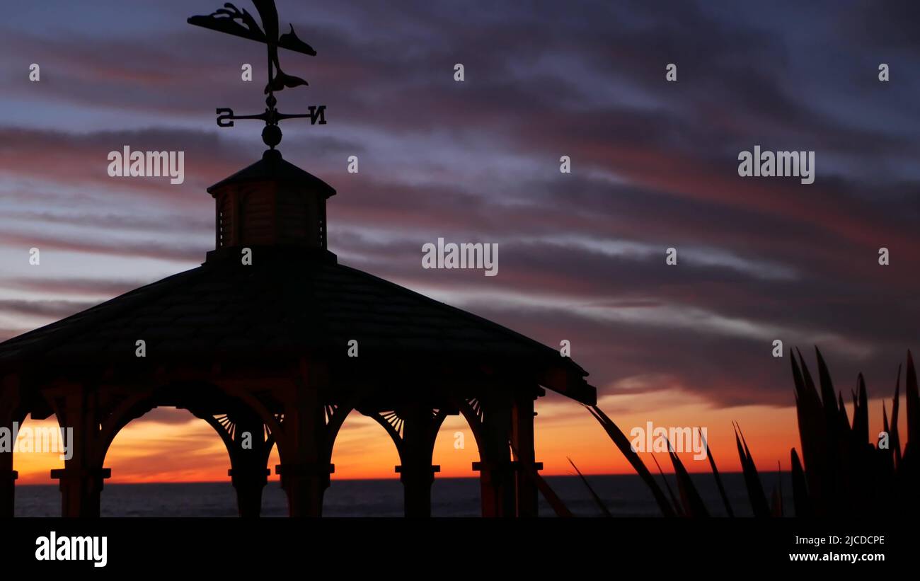Sunset cloudscape and gazebo silhouette on beach, twilight dusk, clouds