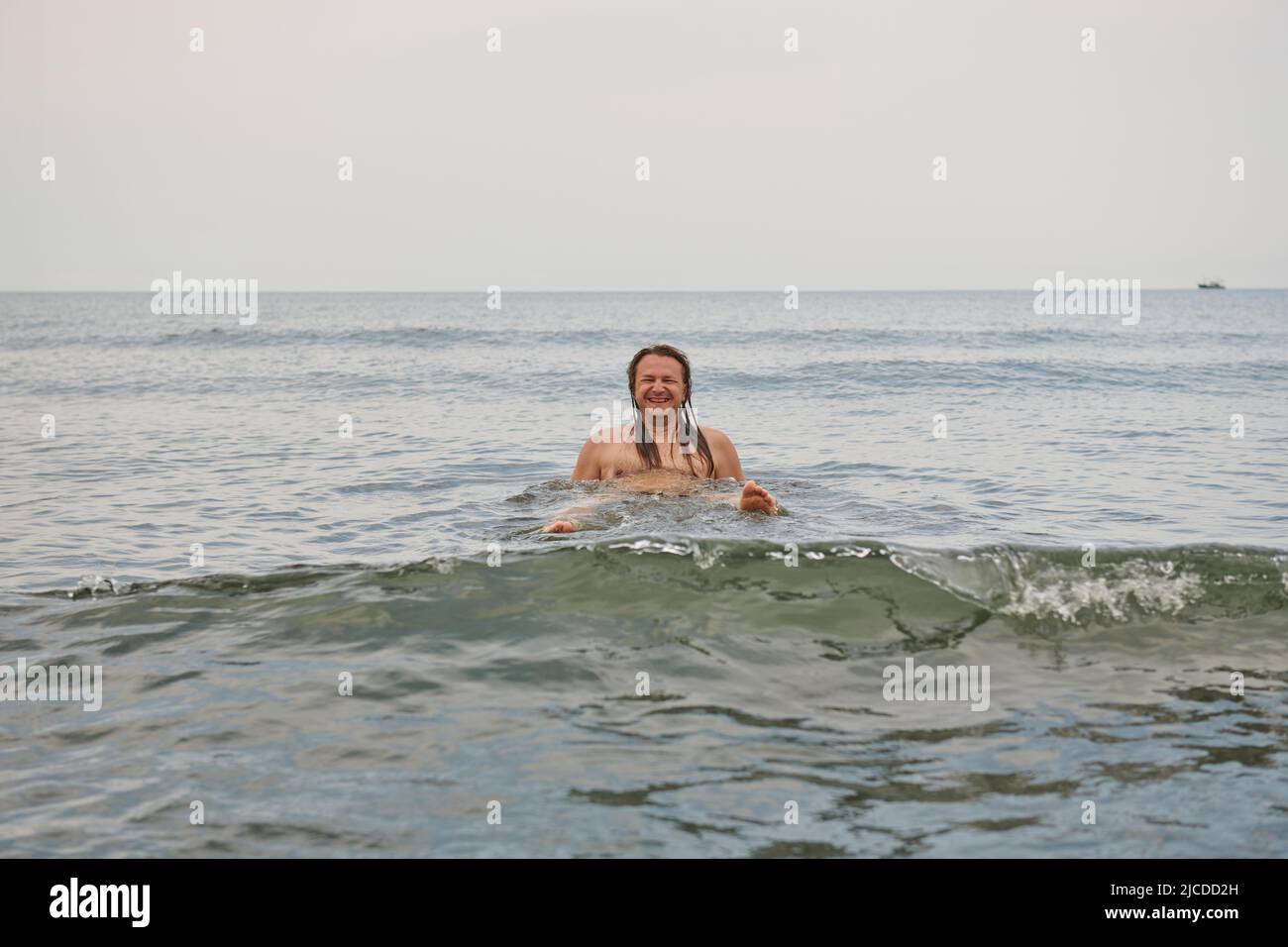a young man with long hair in the sea Stock Photo