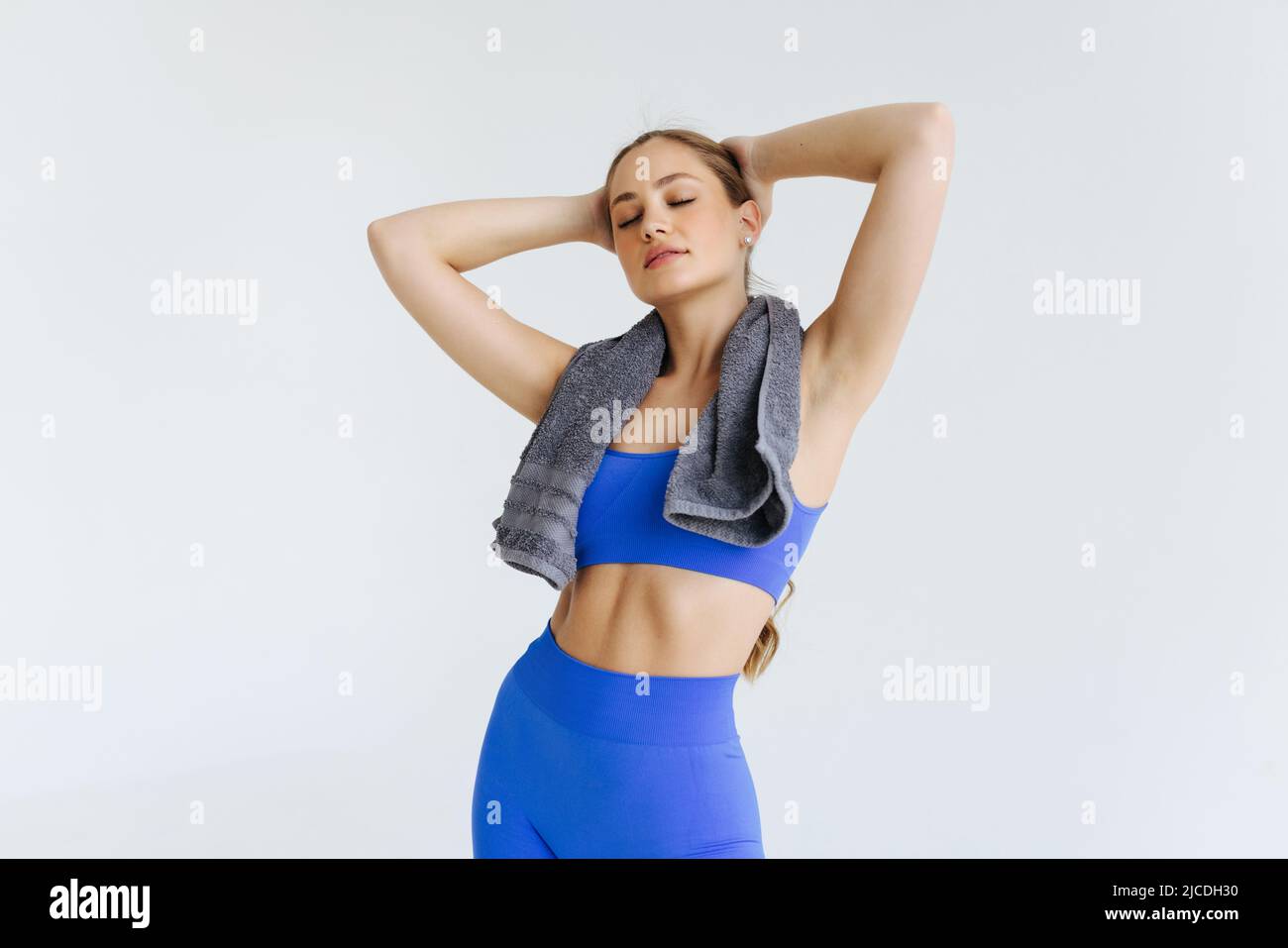 Cheerful joyful young woman athlete with towel standing and smiling ...