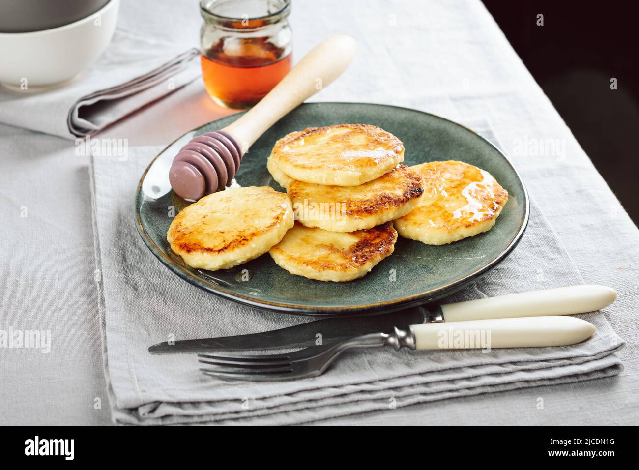 Cottage cheese pancakes with honey for breakfast. Stock Photo