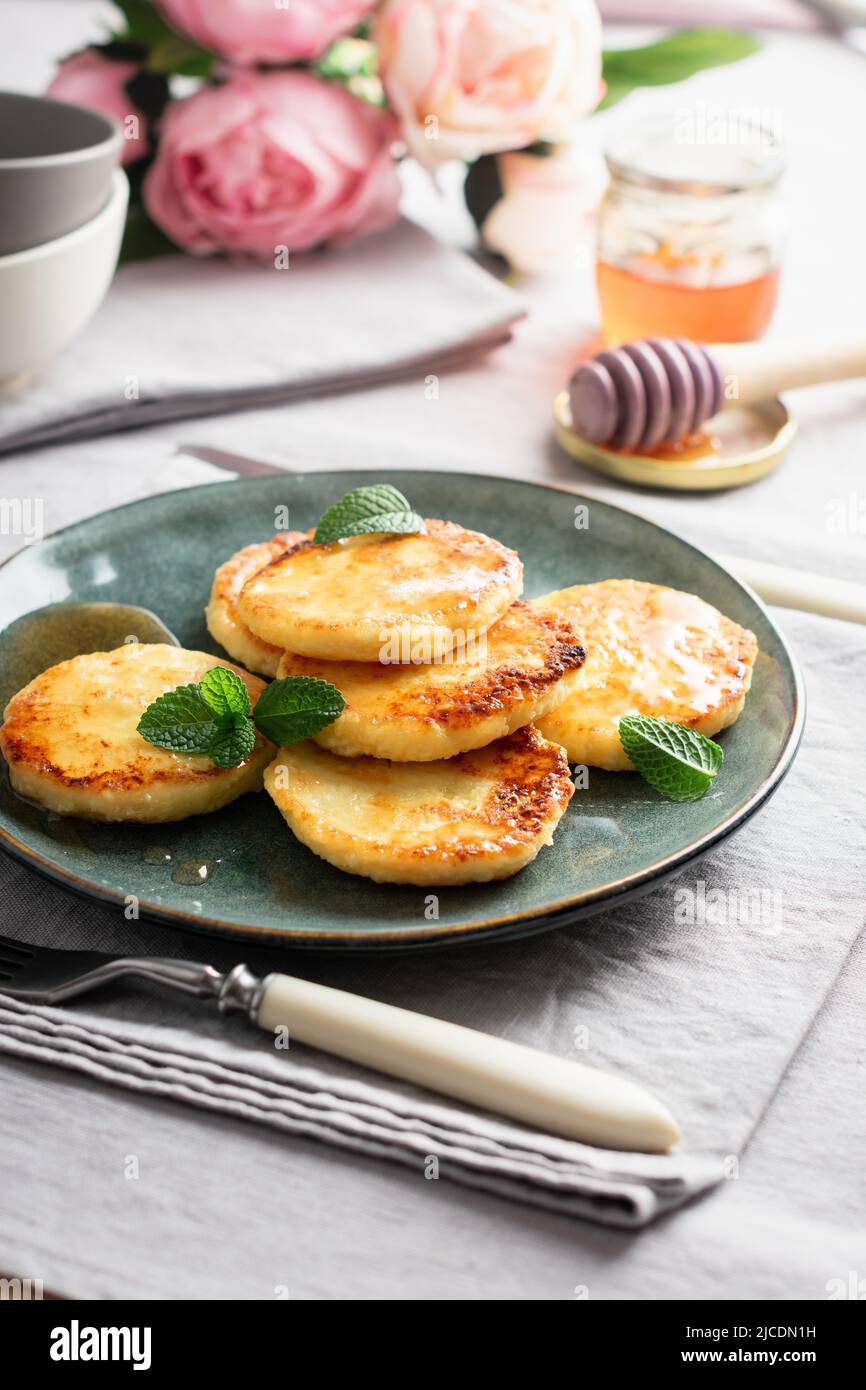 Cottage cheese pancakes with honey for breakfast. Stock Photo