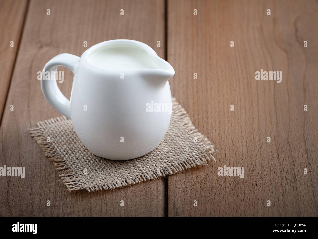 a white ceramic milk pot on a white background Stock Photo - Alamy