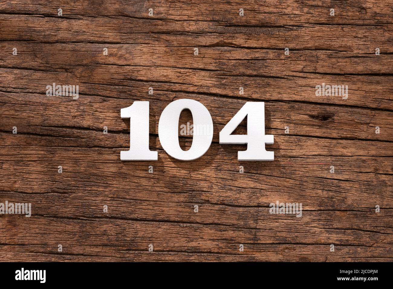 Number 104 in wood, isolated on rustic background Stock Photo - Alamy
