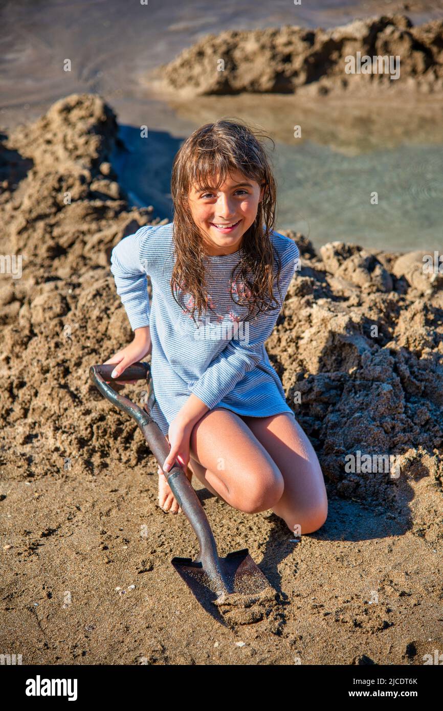 Young girl building a sand SPA at Hot Water Beach, Coromandel Peninsula, New Zealand. Stock Photo