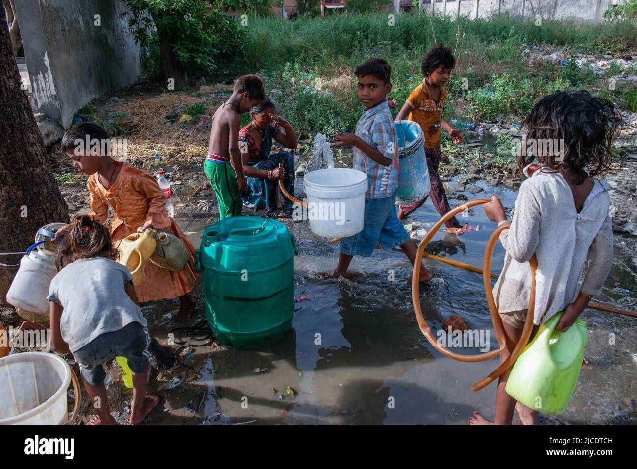 Container Slum Slum children carry containers as they come to collect drinking water ...