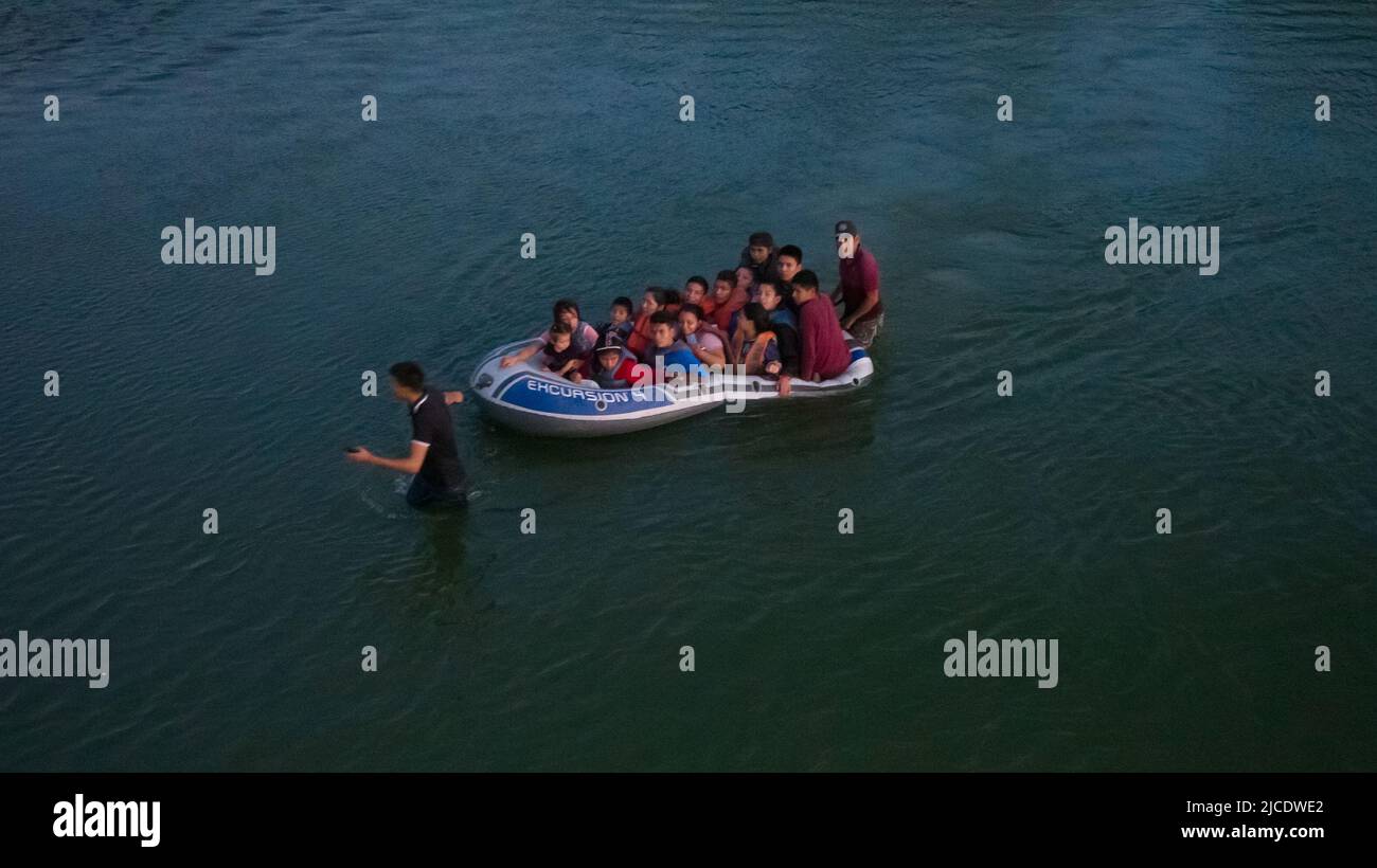 Asylum seeking migrants from Central and South America are smuggled on a raft across the Rio Grande river into the United States from Mexico in Roma, Texas, U.S., June 11, 2022. Picture taken June 11, 2022. Picture taken with a drone. REUTERS/Adrees Latif Stock Photo