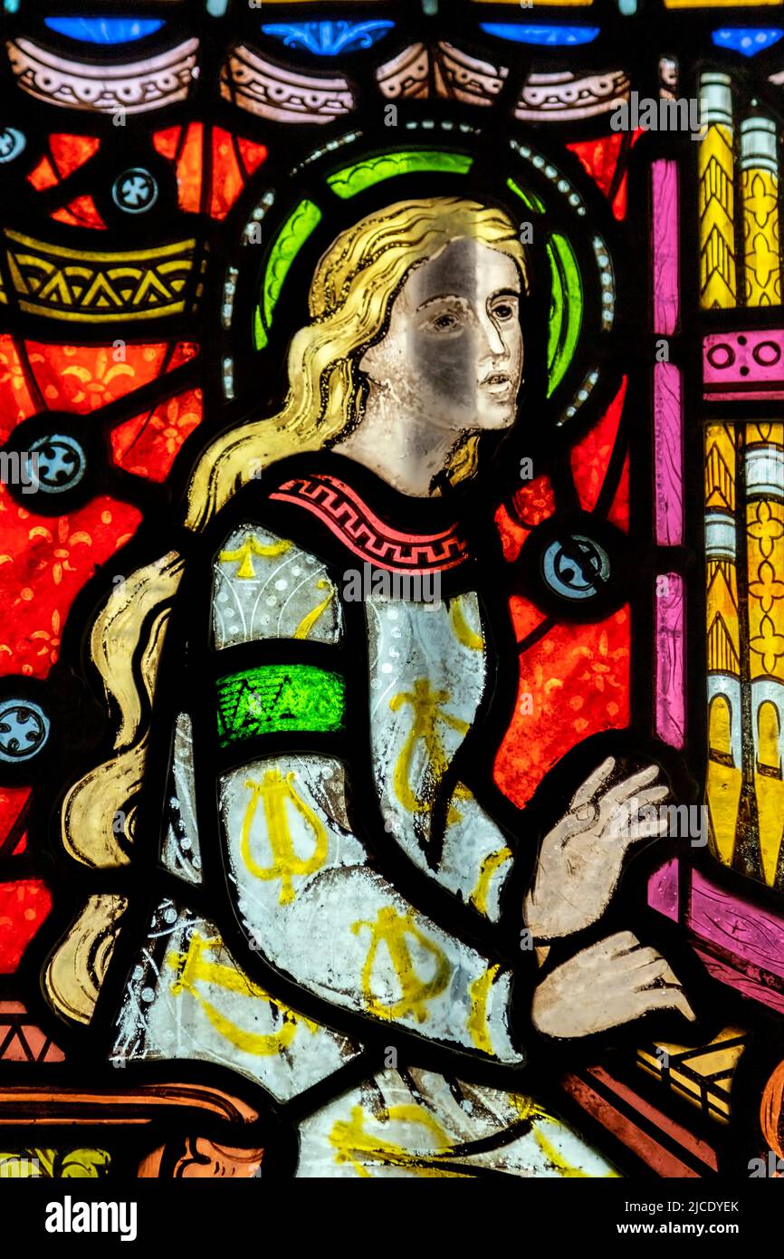 Detail of a stained glass window in St Mary’s Chapel, Sudeley Castle, showing a pipe organ being played. Stock Photo