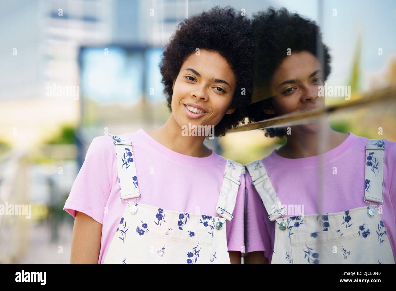 Optimistic African American woman in casual clothes looking at the camera smiling. Stock Photo