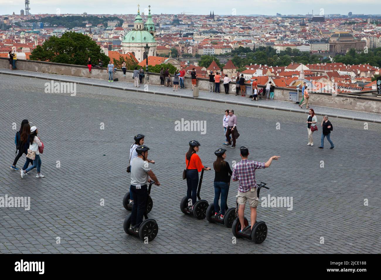 Tourists drive segway during a guided tour in Hradčanské Square in Hradčany district in Prague, Czech Republic. Stock Photo