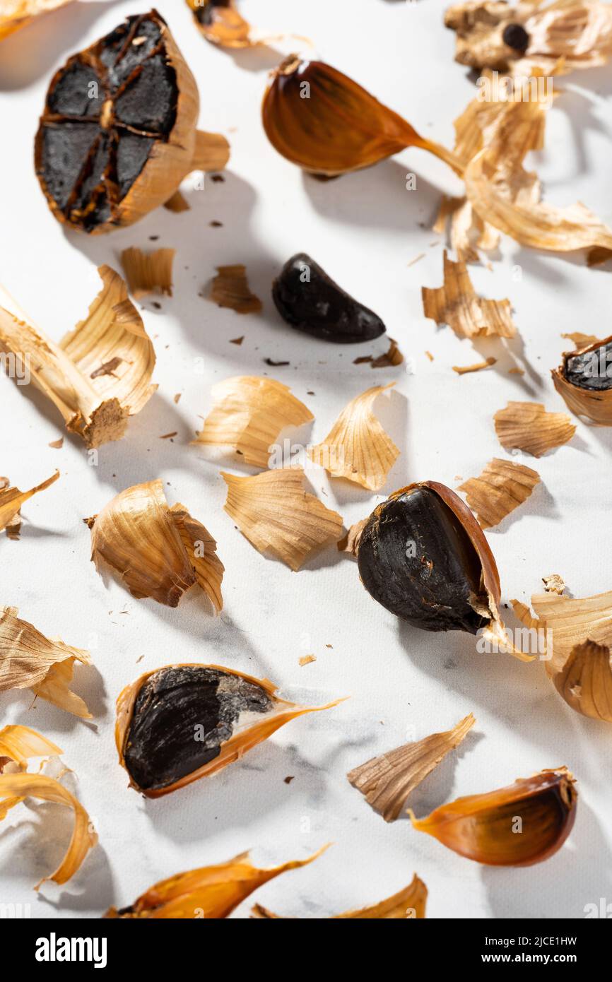 Mess on the kitchen table with peel and fermented garlic cloves. Cloves