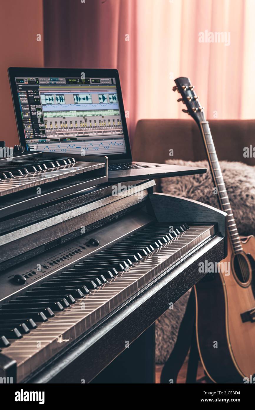 Electronic piano and guitar in room interior. Stock Photo