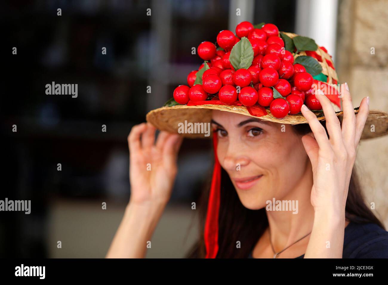 Hammana, Lebanon. 12th June, 2022. A woman shows a cherry hat at the Hammana Cherry Festival in