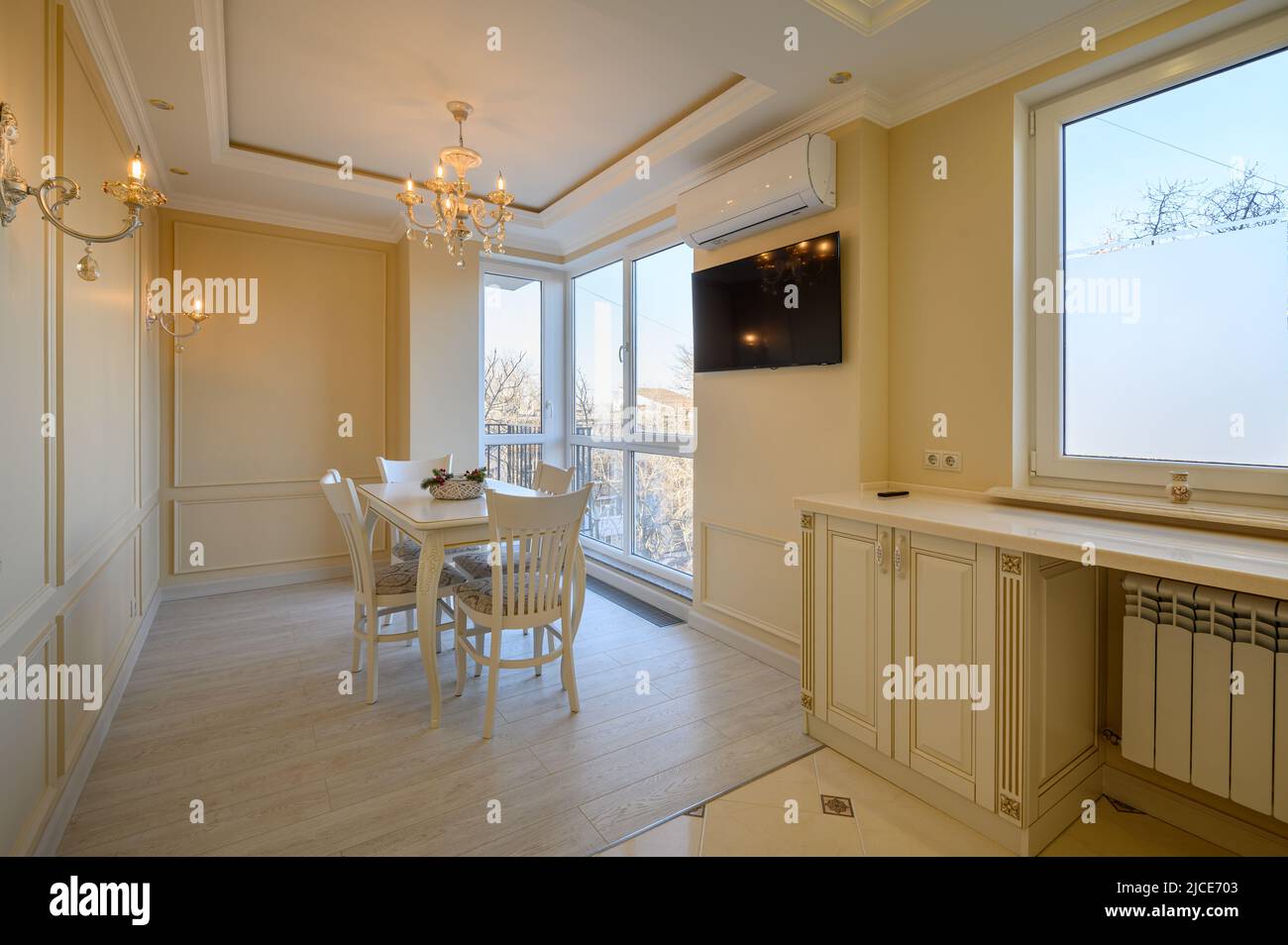 Classic white and beige large kitchen with dining table in studio