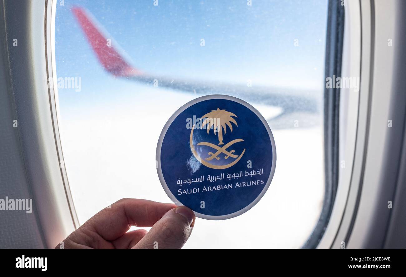 December 6, 2021, Jeddah, Saudi Arabia. The emblem of the airline Saudi Arabian Airlines on the background of the window of the aircraft. Stock Photo