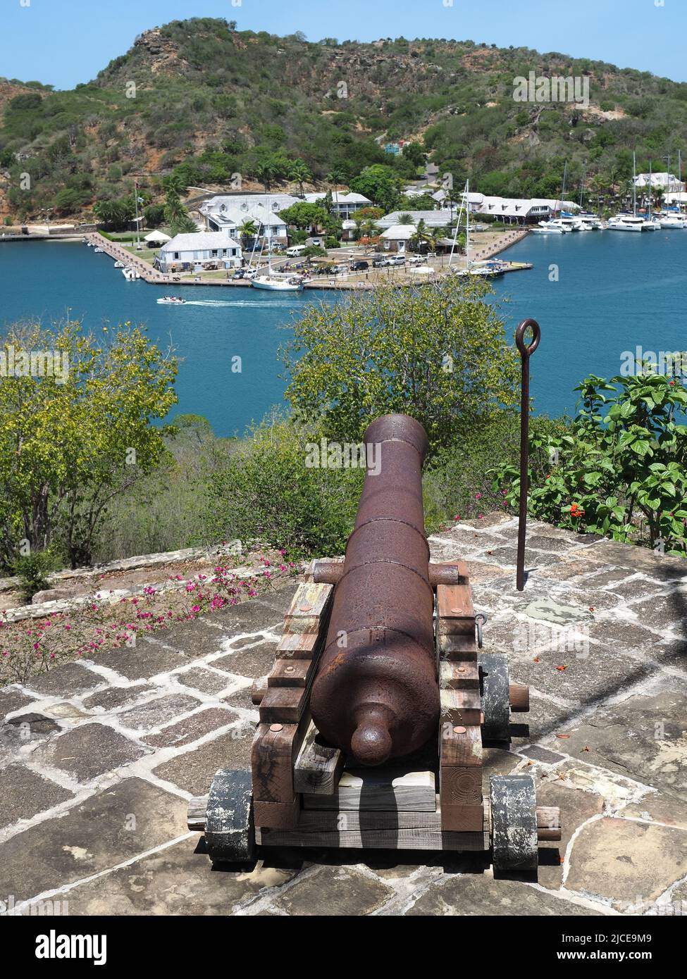 View from behind an old cannon looking out over English Harbour in Antigua towards Nelson's Dockyard Stock Photo
