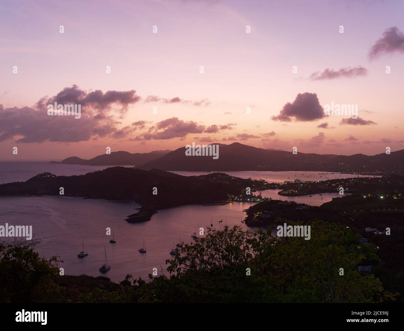 View from Shirley Heights Lookout in Antigua looking down on English Harbour at sunset and with Falmouth Harbour in the distant background Stock Photo