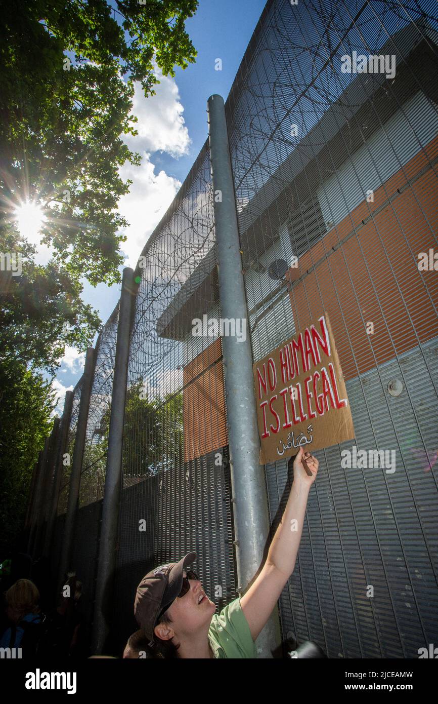 Protesters chant and hold placards against the UK deportation flights to Rwanda outside Brook House Immigration Removal Centre on June 12, 2022 in Lon Stock Photo