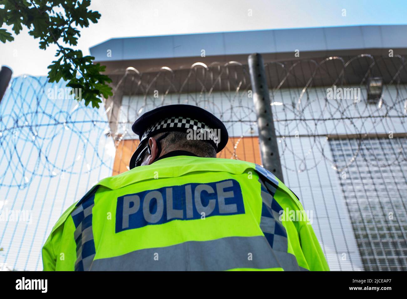 Police stand guard at perimeter fencing against the UK deportation flights to Rwanda outside Brook House Immigration Removal Centre on June 12, 2022 i Stock Photo