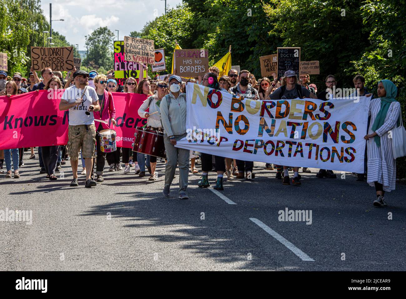 Protesters chant and hold placards against the UK deportation flights to Rwanda near Brook House Immigration Removal Centre on June 12, 2022 in London Stock Photo