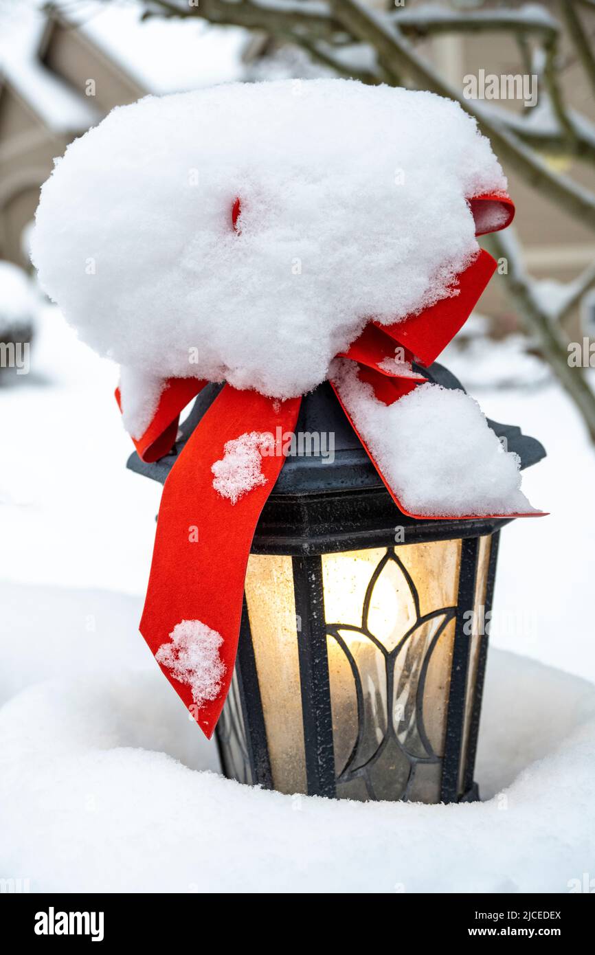 outdoor lamp coveed in snow with a red bos Stock Photo