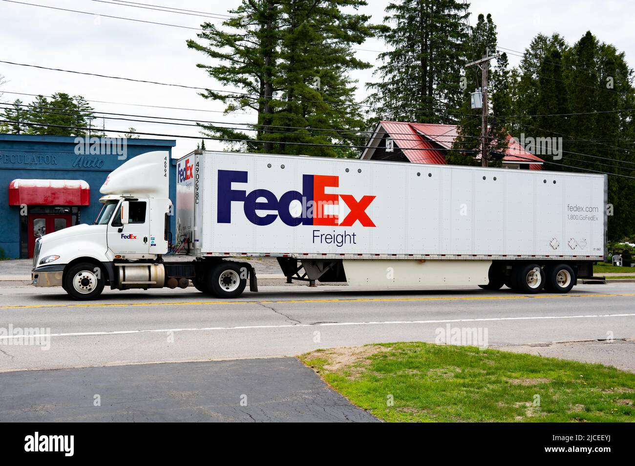 A white FedEx freight tractor trailer truck driving through Speculator, NY Stock Photo