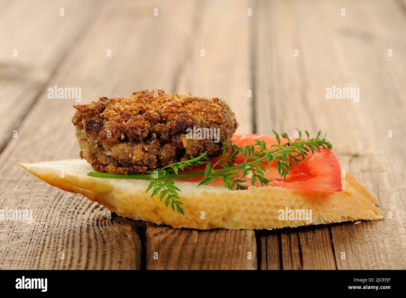 Lentil patty bruschetta with tomato and carrot greens horizontal Stock Photo