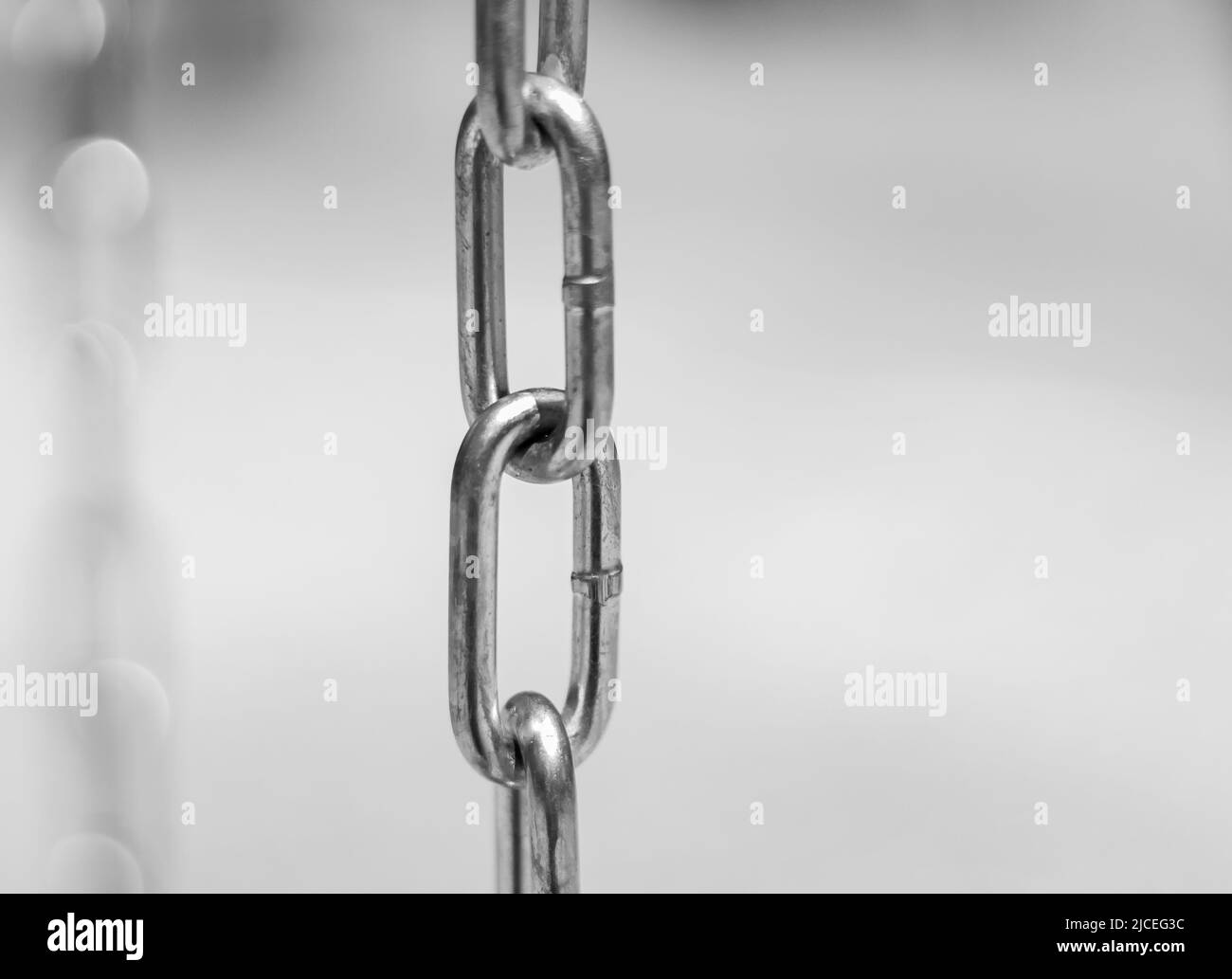 Diagonal, partial blurred iron chain on blurred background. Low angle view of steel chains. Nobody, copy space for text, selective focus Stock Photo