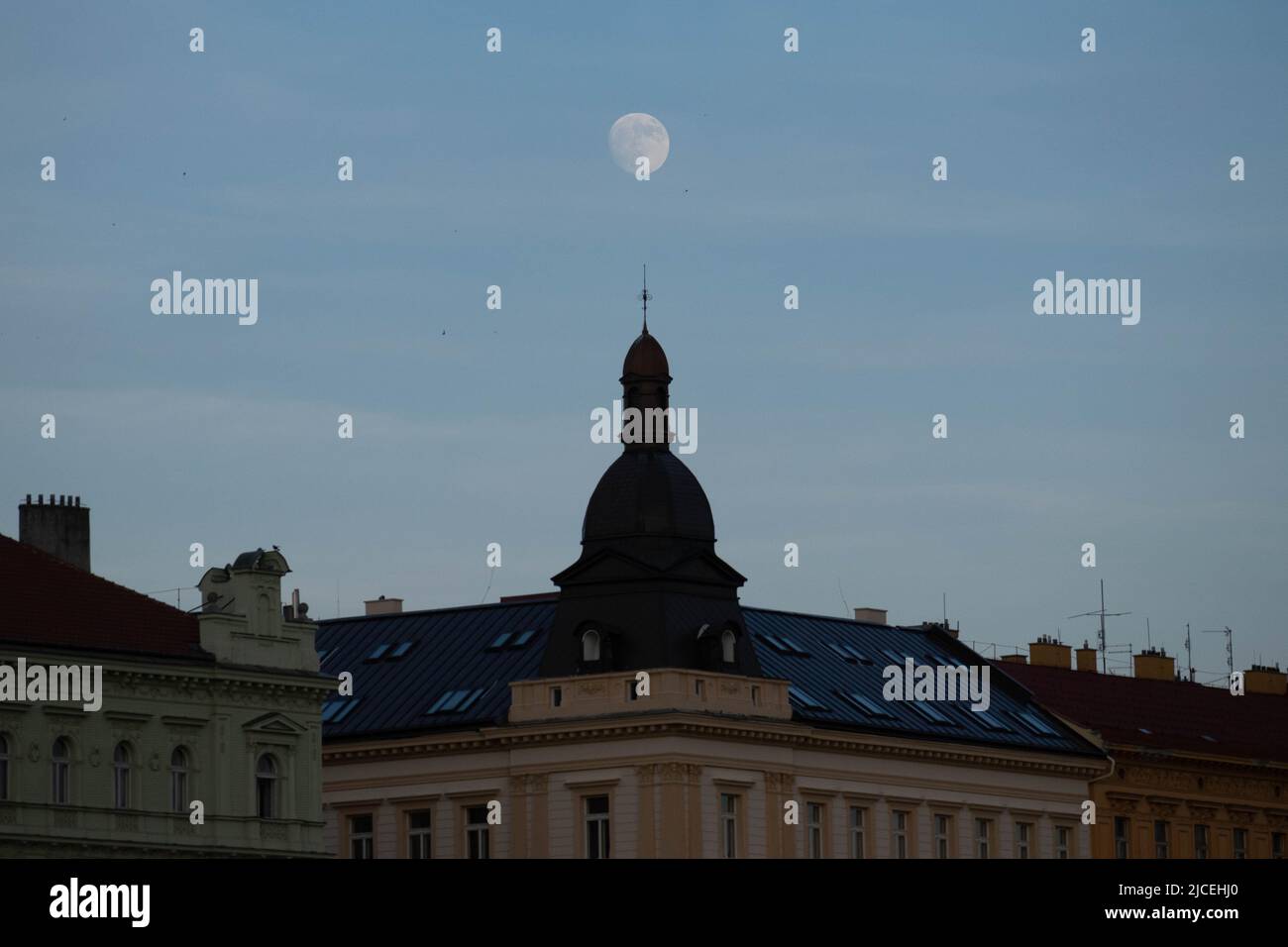 Prague, Santiago, Czech Republic. 12th June, 2022. The nearly full June moon appears over buildings in Prague, Czech Republic, at sunset. (Credit Image: © Matias Basualdo/ZUMA Press Wire) Stock Photo